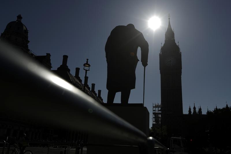 A statue of Winston Churchill stands silhouetted in front of the Houses of Parliament in London, Monday, June 19, 2017.