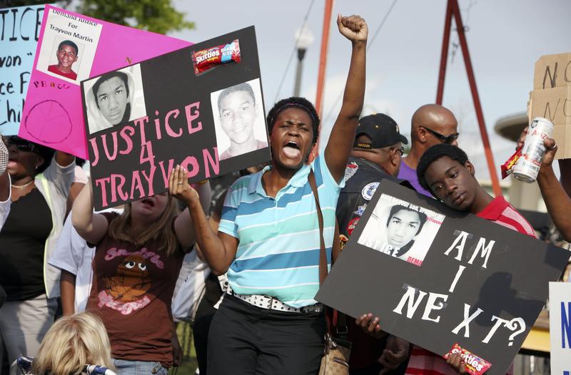 In this March 22, 2013 photo, protestors, Lakesha Hall, 32, of Sanford, center, and her son, Calvin Simms, 12, right, gather for a rally for Trayvon Martin, the black teenager who was fatally shot.