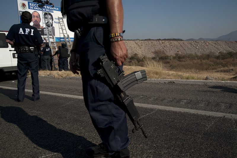 Soldiers and Federal Police officers install a checkpoint on a road inside the zone of influence of La Familia drug cartel on December 12, 2010 in Apatzingan, Mexico.
