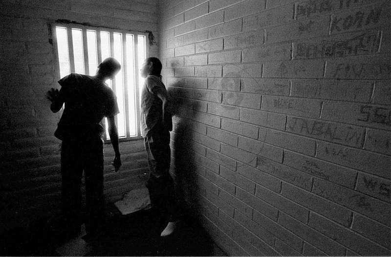 Two juveniles look out of a cell at the Bisbee Juvenile Detention Center in Bisbee, Arizona, November 15 1995.