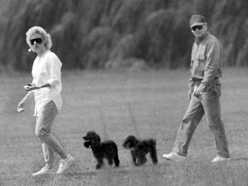 Whitey Bulger and Catherine Greig walk together with Greig's poodles underfoot.