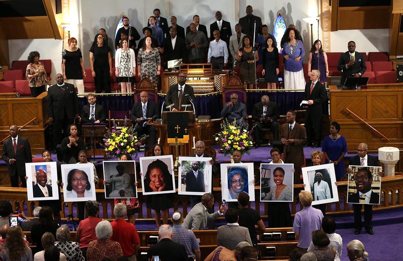 Photographs of the nine victims killed at the Emanuel African Methodist Episcopal Church in Charleston, South Carolina are held up by congregants during a prayer vigil on June 19, 2015.