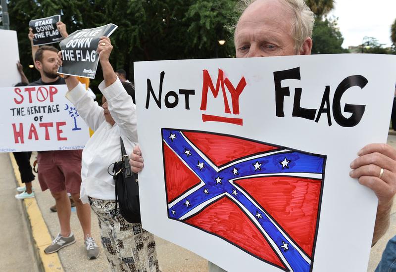 A man holds a sign up during a protest rally against the Confederate flag in Columbia, South Carolina on June 20, 2015.