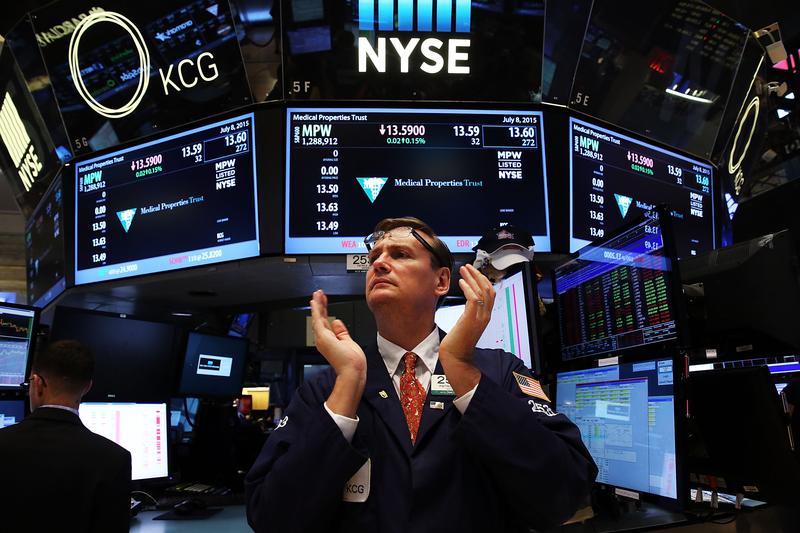 A trader claps on the floor of the New York Stock Exchange (NYSE) at the close of the day after trading was paused for nearly four hours due to a 'technical glitch' on July 8, 2015 in New York City.
