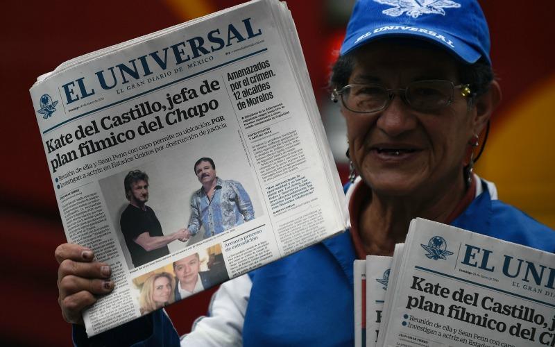 A vendor sells newspapers showing a picture of drug lord Joaquin Guzman, aka 'El Chapo' (R), shaking hands with US actor Sean Penn, in Mexico City on January 10, 2016.