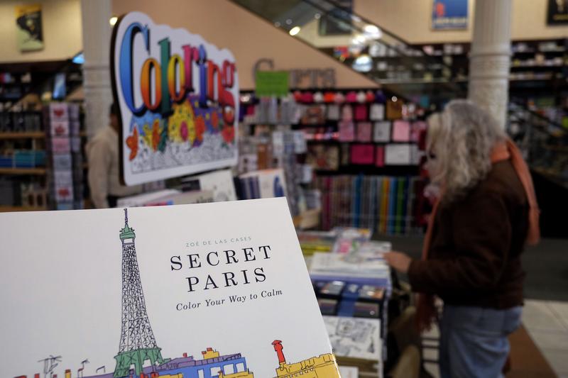 A woman checks out coloring pencils next to adult coloring books at a Barnes and Nobel store in New York.