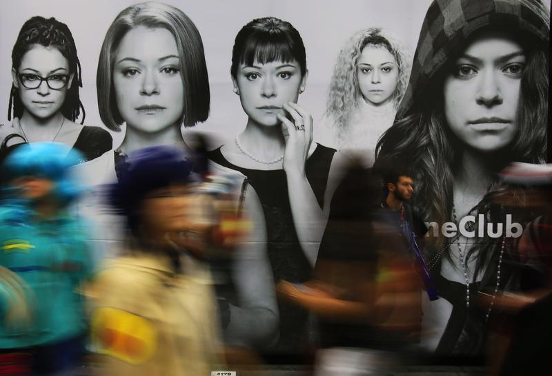 Fans pass by BBC America's Orphan Black ad on a convention hall wall during Comic-Con International in San Diego, July 26, 2014.