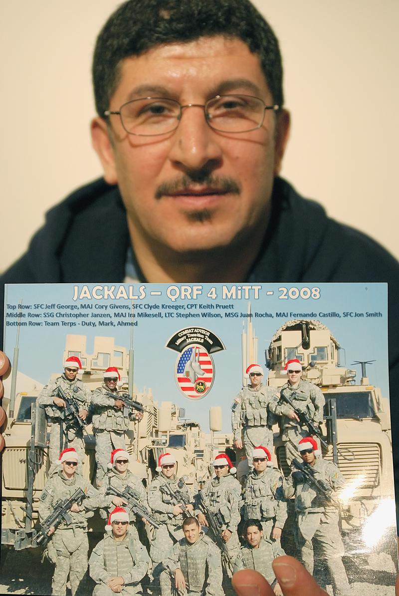 This December 15, 2010, file photo shows Iraqi refugee Ayad Salman in Chicago, Illinois, holding a picture of one of the US units he worked with as a translator in Iraq before fleeing the country.