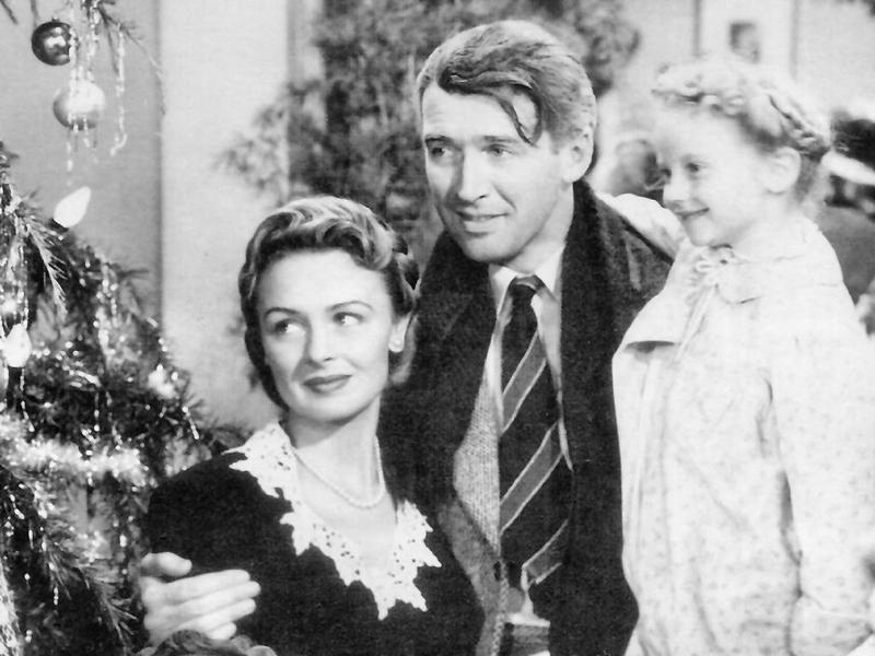 A screenshot of Jimmy Stewart, Donna Reed and Karolyn Grimes in the film 'It's a Wonderful Life.'