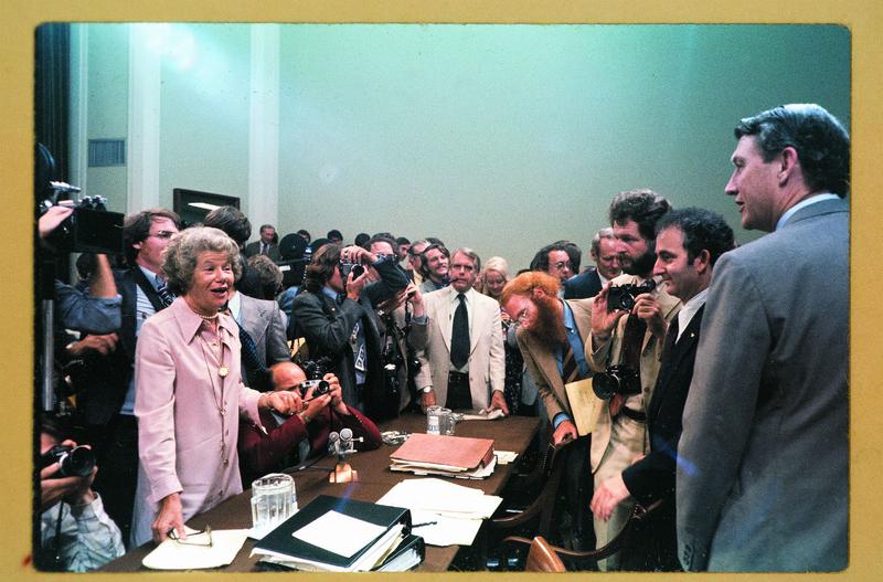 Mary McGrory standing on the left at the Watergate Hearings.