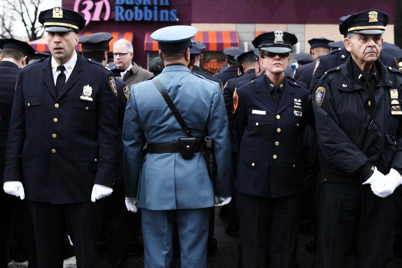 Many police officers turn their back while Mayor Bill de Blasio speaks at the funeral of NYPD officers Wenjian Liu. This, despite pleas from the police commissioner not to protest at funerals.