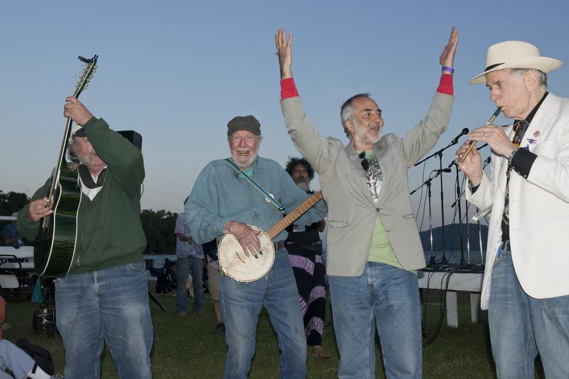(L-R) unknown guitarist, Pete Seeger (banjo), Raffi Cavoukian, David Amram (tin whistle) play in front of the Hudson River at the Clearwater Festival in Croton Point Park in Croton-on Hudson, N.Y.