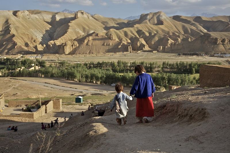 Aqila, 8, leads her 18 month old brother, Abdul Wahid, down the hill, towards other children who are playing in the village of Ragshad, in the central Bamyan Province, Afghanistan, 2007.