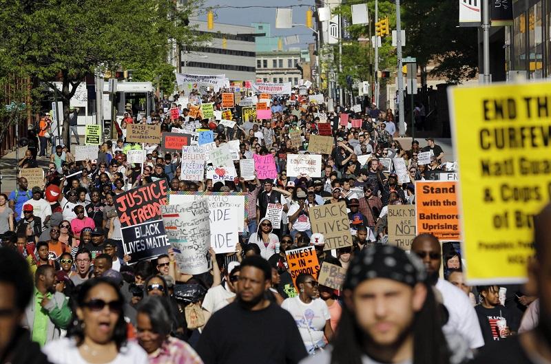 In this May 2, 2015, file photo, protesters march through Baltimore the day after charges were announced against the police officers involved in Freddie Gray's death.