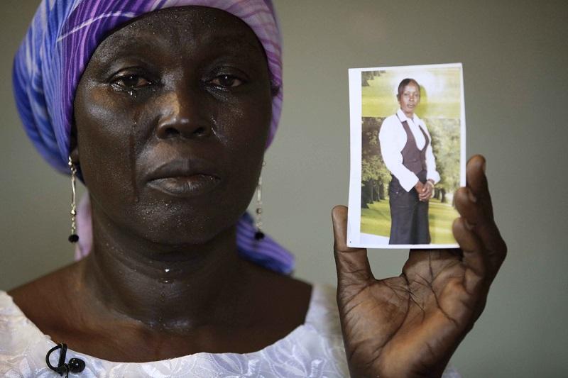 In this Monday, May 19, 2014 file photo, Martha Mark, the mother of kidnapped school girl Monica Mark cries as she displays her photo, in the family house, in Chibok, Nigeria.