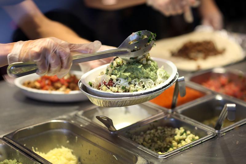 Chipotle restaurant workers fill orders for customers on the day that the company announced it will only use non-GMO ingredients in its food on April 27, 2015 in Miami, Florida.