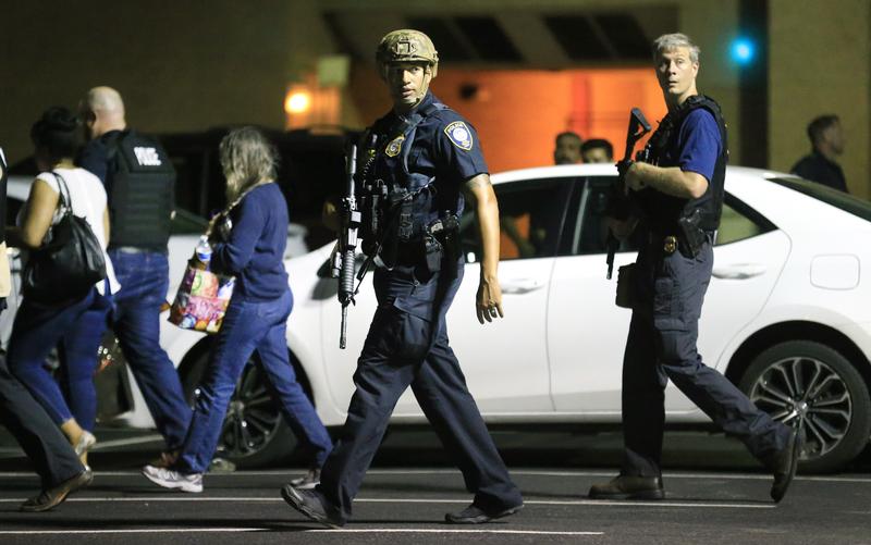 Dallas police officers escort residents near the scene where 11 police officers were shot and five have now died on July 8, 2016 in Dallas, Texas.