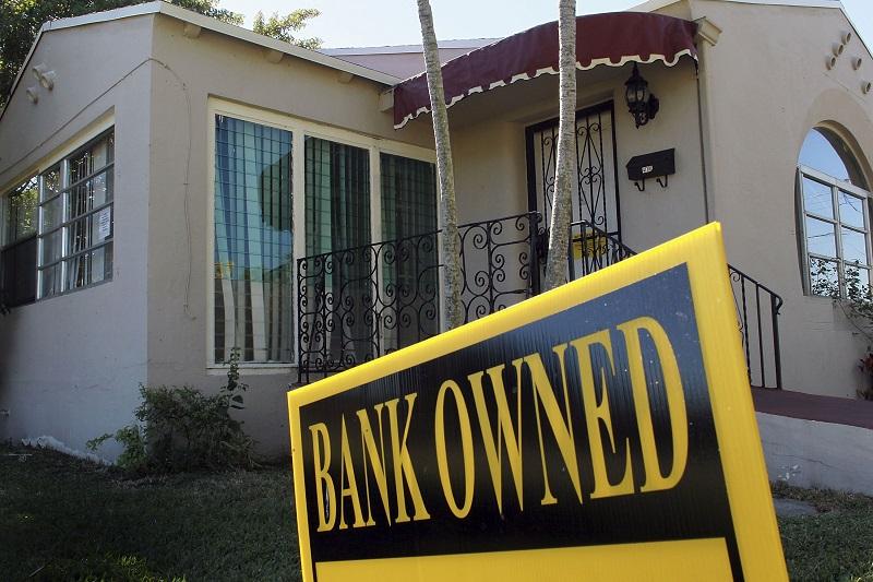 A bank owned sign is seen in front of a foreclosed home on December 7, 2010 in Miami, Florida.