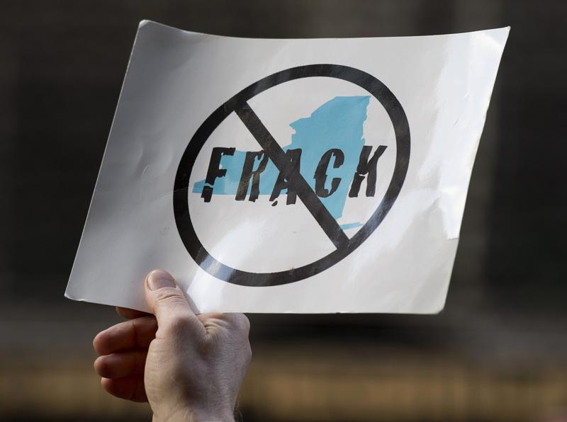 An opponent of the hydraulic fracturing holds a sign during a demonstration at the site of a Democratic party fundraiser March 20, 2014 in New York.