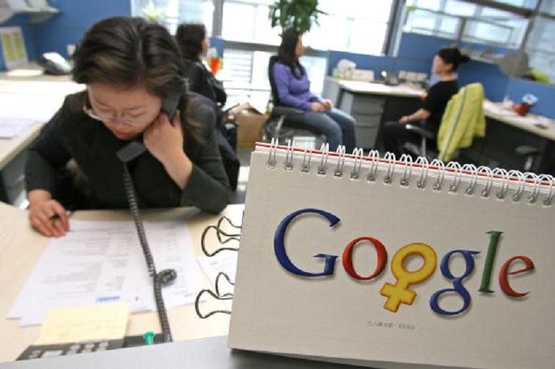 Google employees work by a calendar that features the company's logo changed a little for the month of March in honor of Woman's day (March 8), in their offices in Beijing, China, on March 2, 2006.