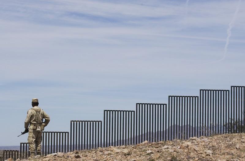A Mexican soldier patrols along the U.S.-Mexico border wall on the outskirts of Nogales, Mexico, Tuesday, April 1, 2008. U.S.