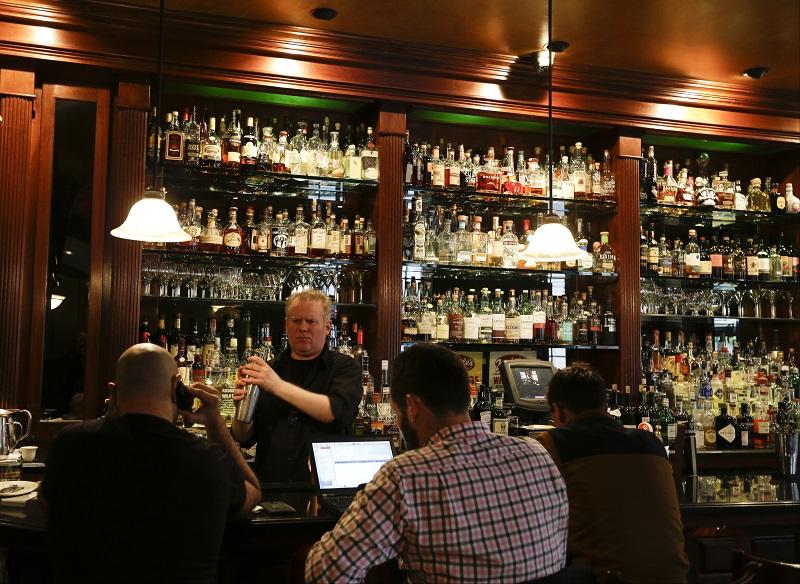 This Oct. 23, 2014 photo shows Mike Burrell works the bar at Daddy-O in New York. Daddy-O has been slinging whiskey since 1999 and offers over 200 bourbons.