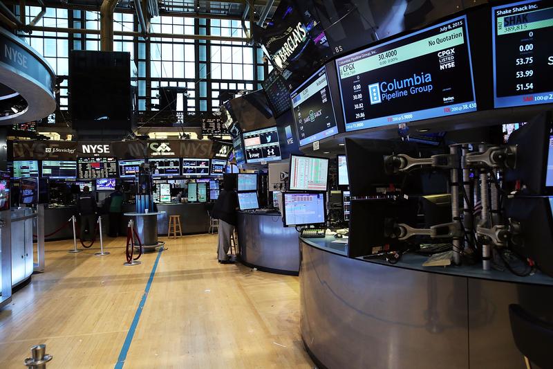 Traders wait on a nearly empty trading floor at the New York Stock Exchange (NYSE) after trading was halted due to a 'technical glitch' on July 8, 2015 in New York City.