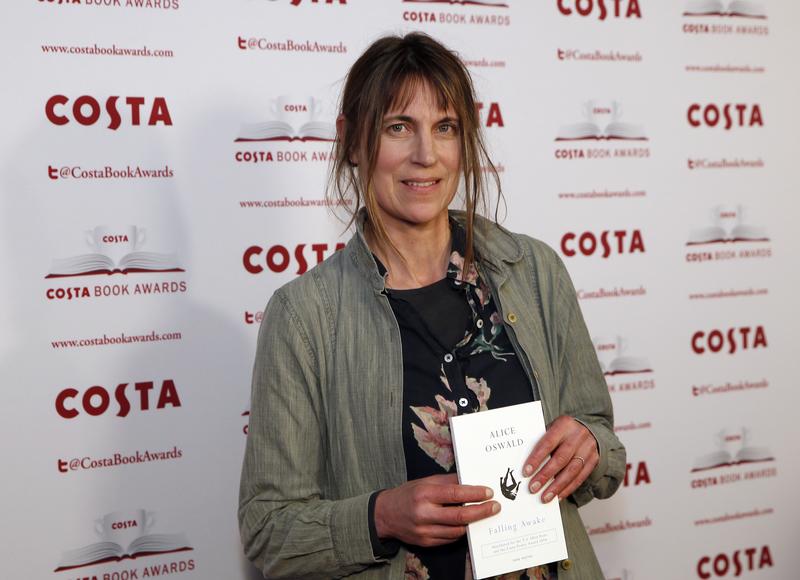 Author Alice Oswald holds up her book "Falling Awake" as she poses for the media at the Costa Book Awards 2016 in London, Tuesday, Jan. 31, 2017.