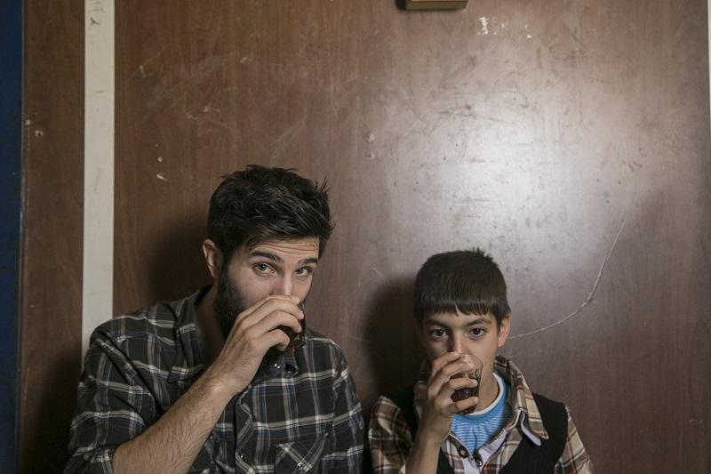 Zach Ingrasci, filmmaker, and Raouf sipping tea in the film, "Salam Neighbor."