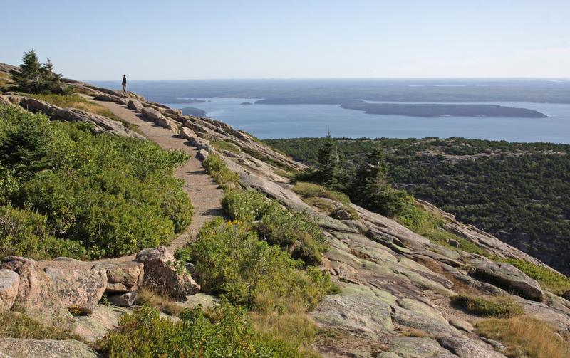 A person enjoying the view from on top of Cadillac Mountain. Located on Mount Desert Island - Acadia National Park, Maine, USA.