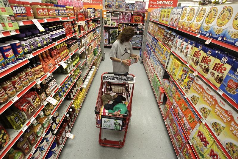 In this Dec. 14, 2010, file photo, Alicia Ortiz shops through the cereal aisle as her daughter Aaliyah Garcia catches a short nap in the shopping cart at a Family Dollar store in Waco, Texas.