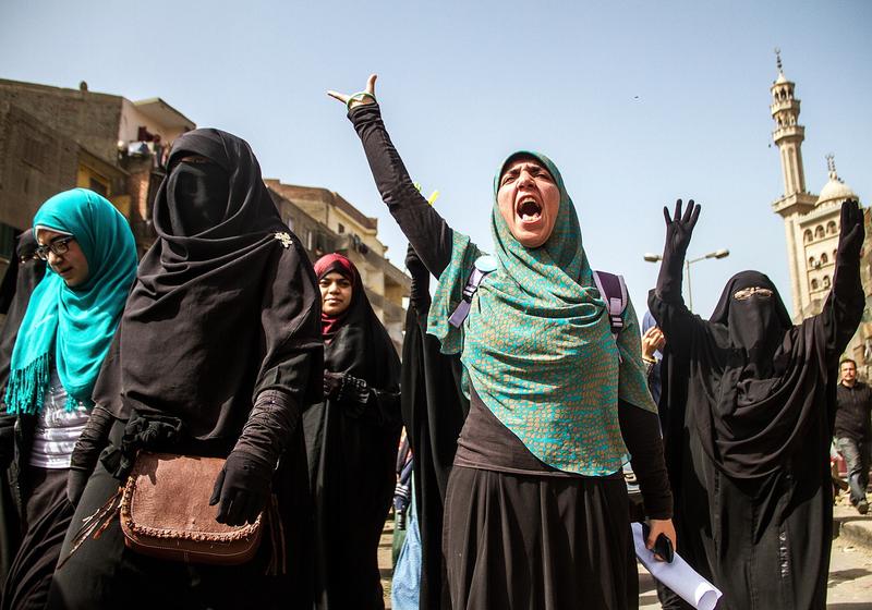 Women flash Rabia sign as Egyptians who call themselves as 'Anti-Coup demonstrators' stage a demonstration in the Al-Matariyyah district of Cairo, Egypt on February 27, 2015.