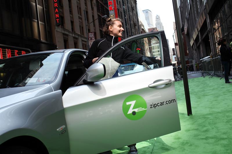 A woman demonstrates how to register into a Zipcar during a promotion of the short term car rental company on April 14, 2011 in Times Square in New York City.
