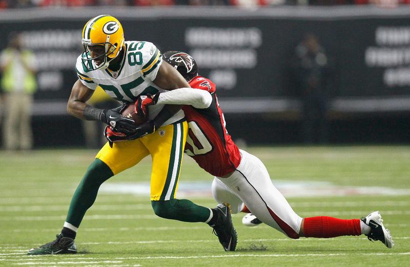 Brent Grimes #20 of the Atlanta Falcons tackles Greg Jennings #85 of the Green Bay Packers at Georgia Dome on November 28, 2010.