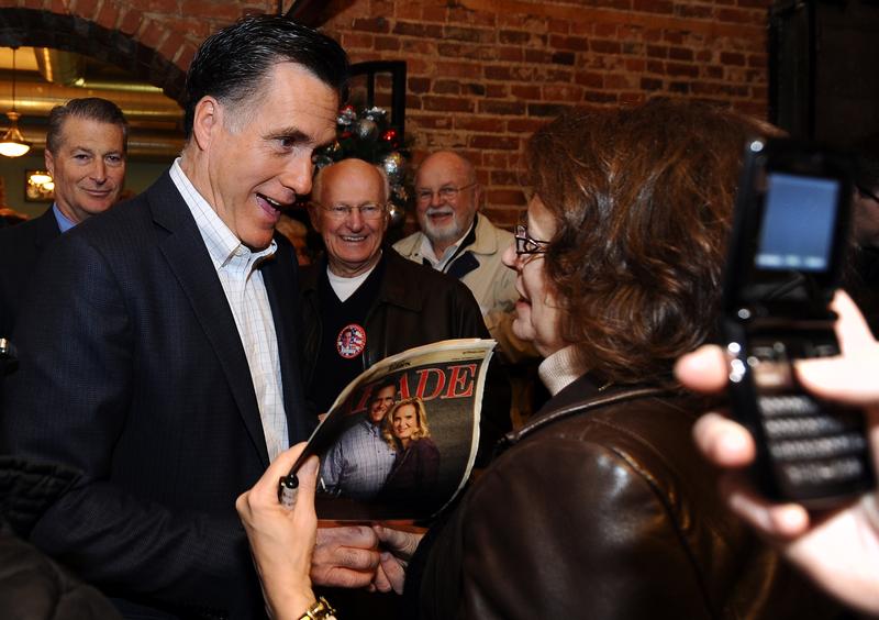 Mitt Romney signs autographs for a supporter during a campaign stop in Muscatine, Iowa.