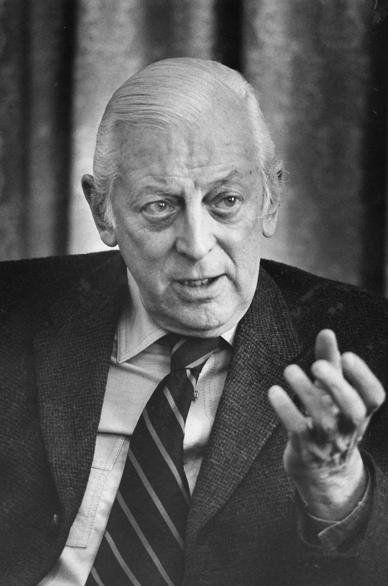 Alistair Cooke, head-and-shoulders portrait, facing front, gesturing with left hand, during interview, March 18, 1974